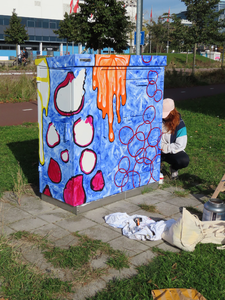 912101 Afbeelding van Melissa de Gier die een van de drie elektriciteitskastjes beschildert, op de hoek van de Van ...